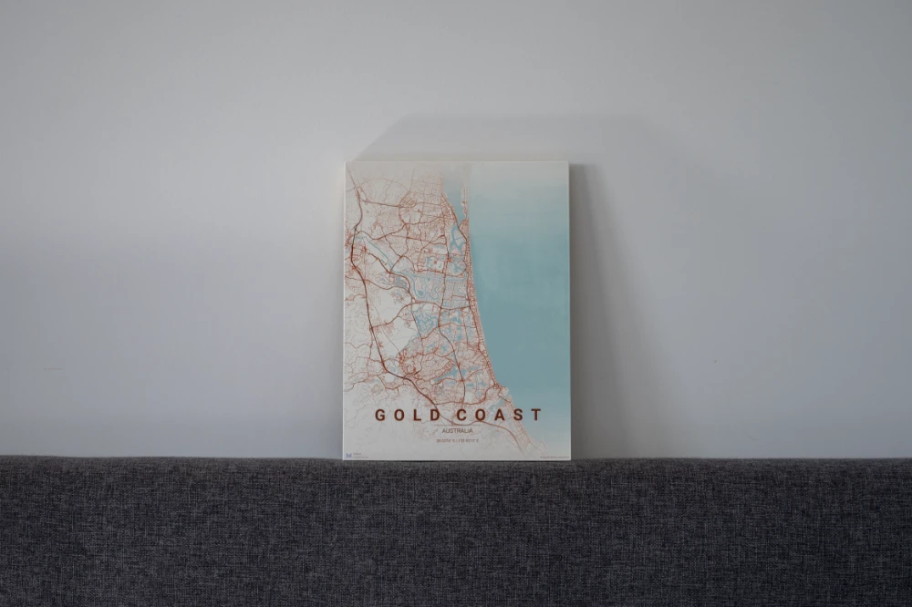 Gold Coast wood-board map leaning on a sofa back