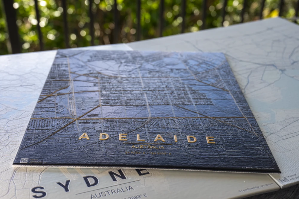 Adelaide wood-board map in gold on a Sydney print